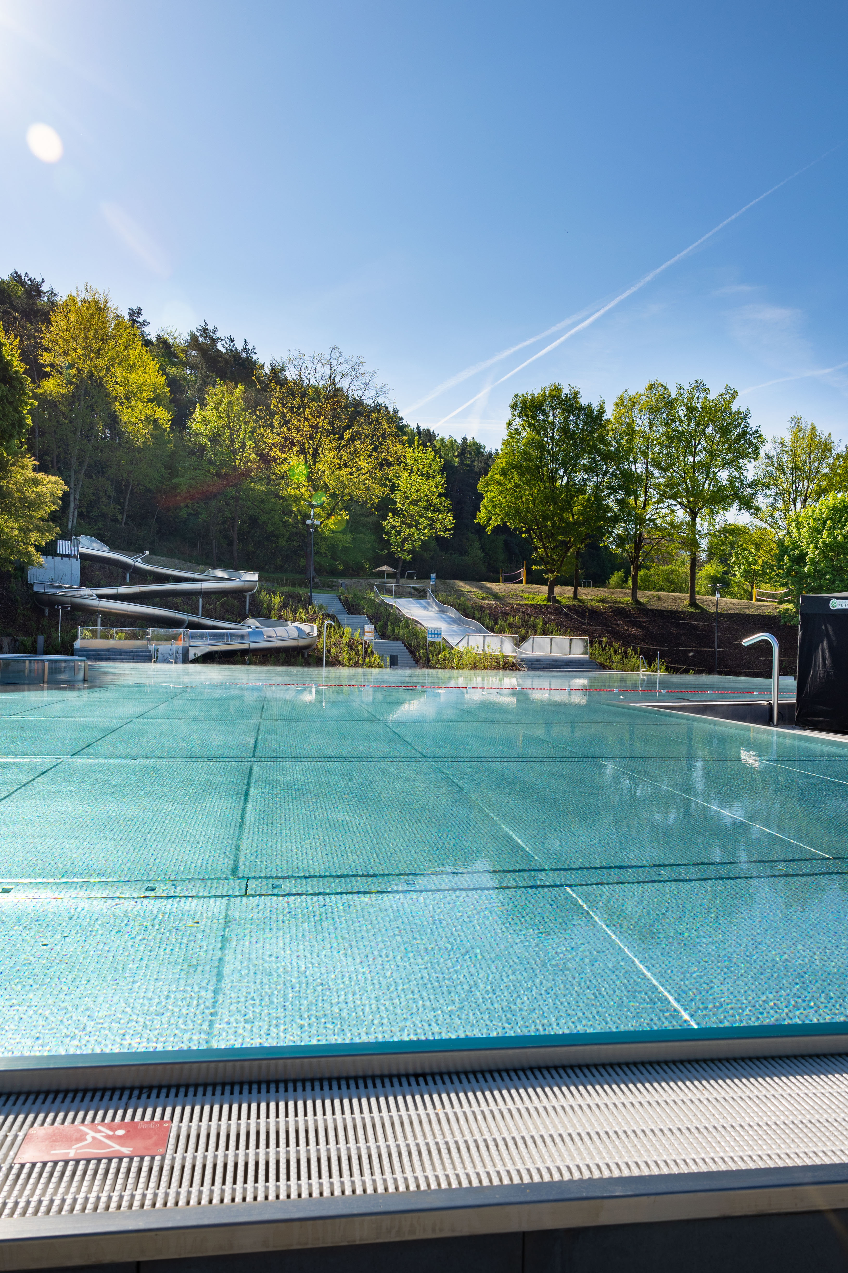 Blick auf das Freibad mit Rutschen und grünem Umfeld