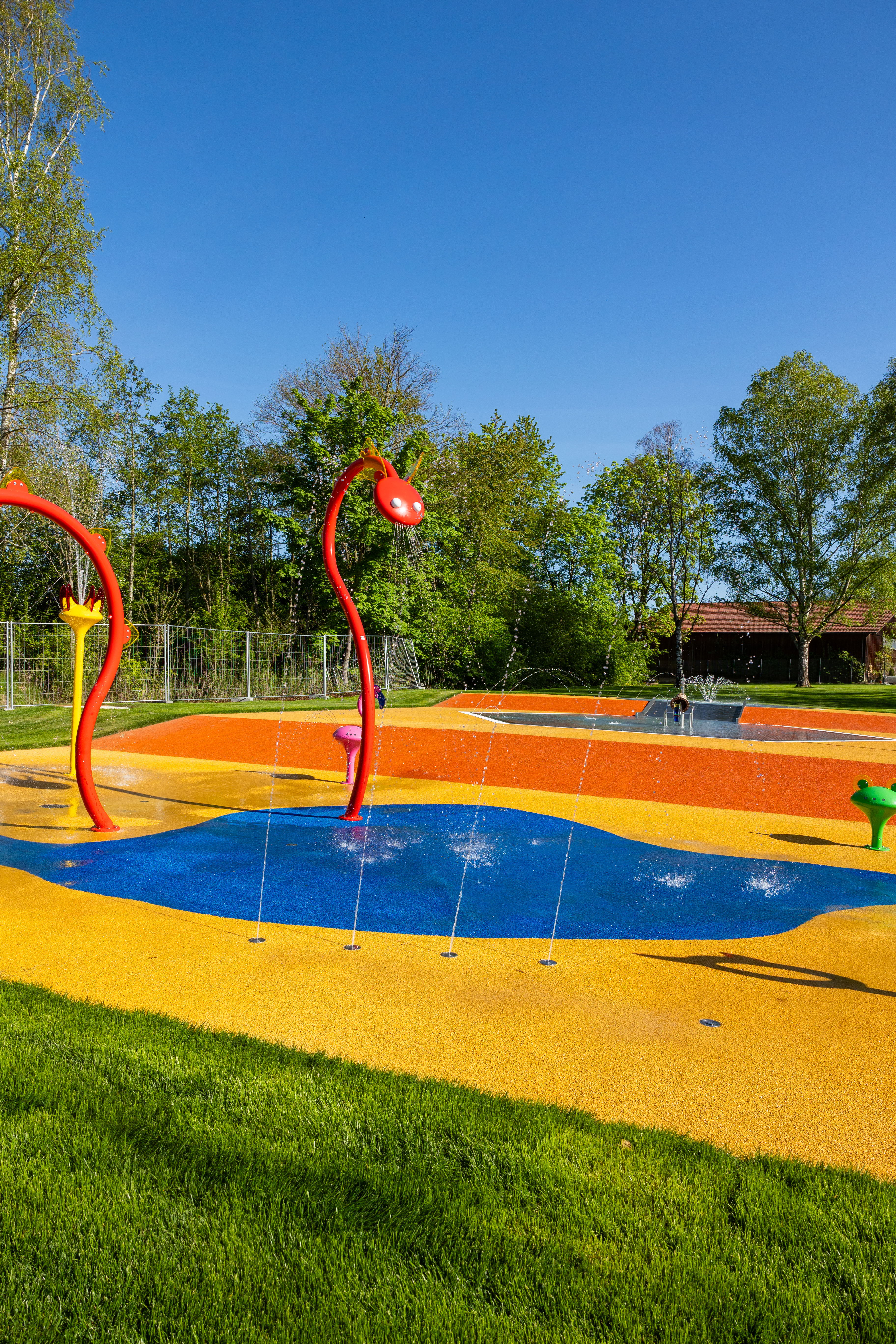 Bunte Wasserspiele mit Spritzdüsen im Freibad