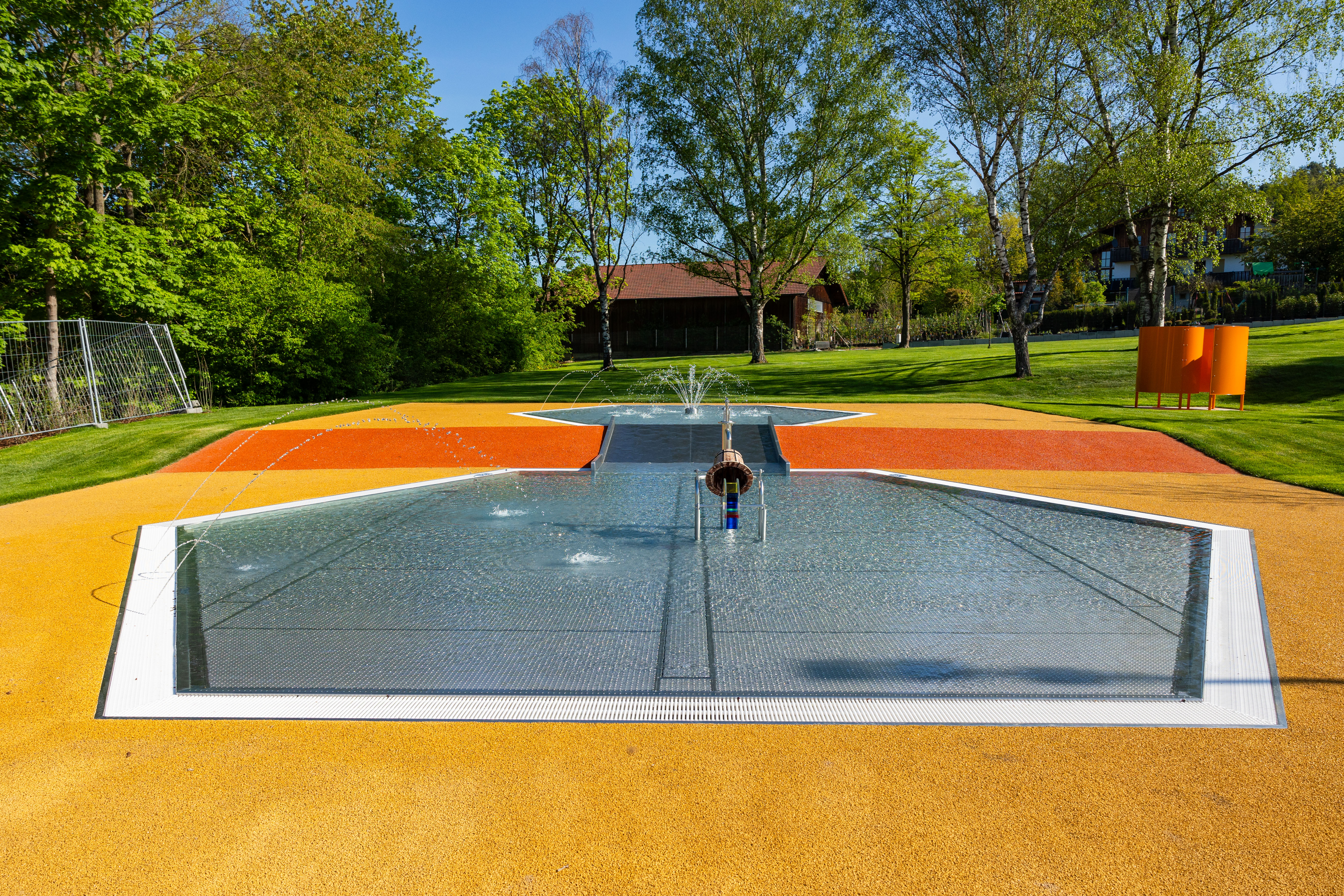 Spritzende Wasserfontänen auf einem bunten Spielplatz