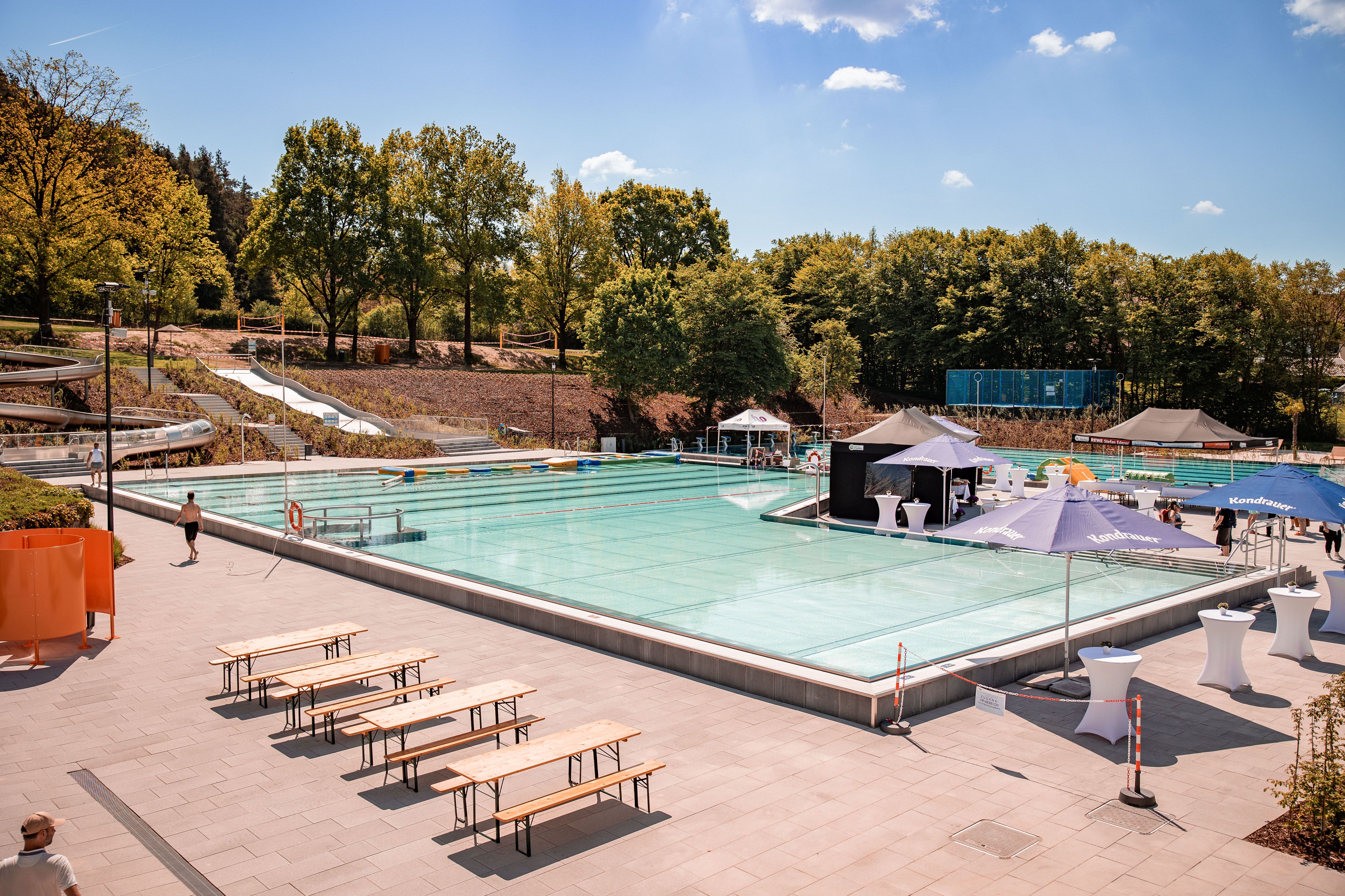 Blick auf das Freibad mit Rutschen und Liegen.